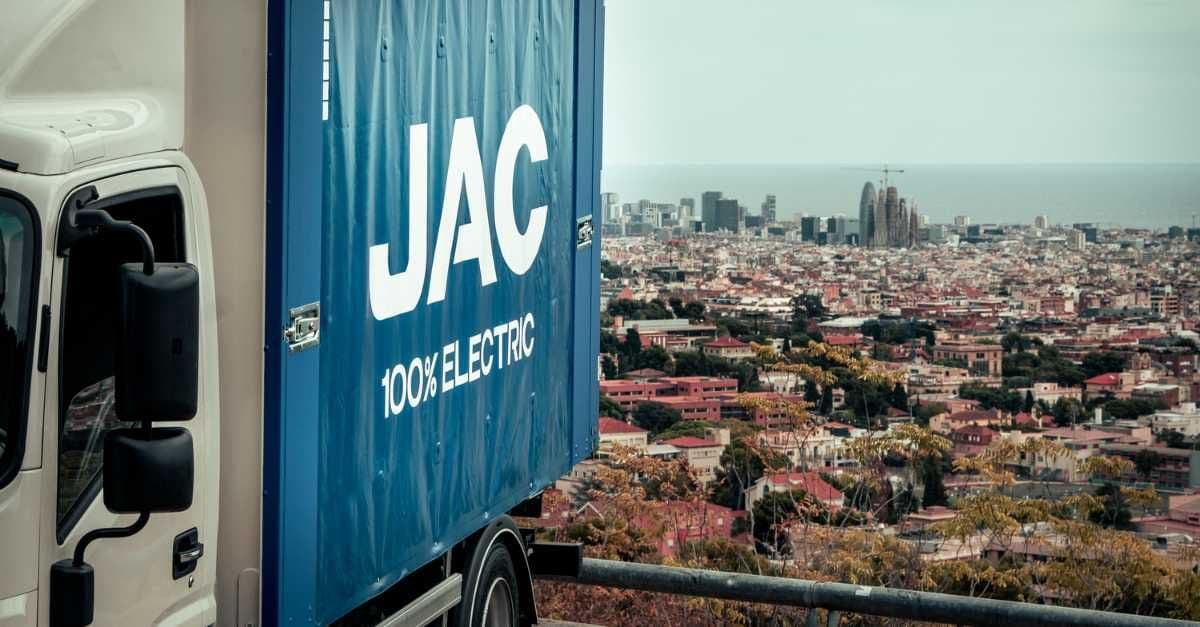 Camión JAC con caja botellera con Barcelona de fondo